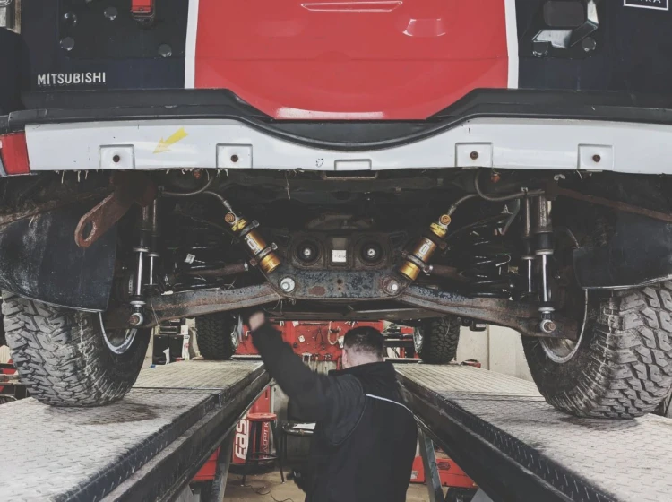 Mechanik wykonuje precyzyjną regulację geometrii kół samochodu osobowego podczas szkolenia w ANWA-TECH