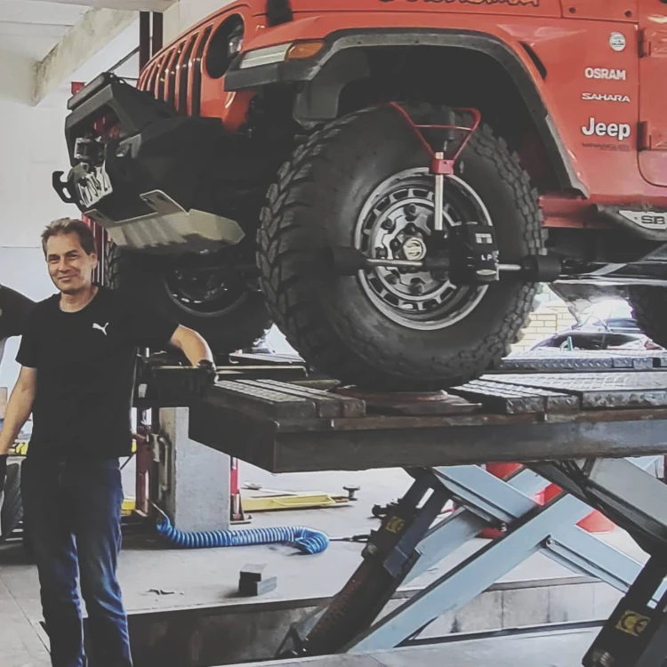 Trener Bogusław Czaplarski prowadzi szkolenie z geometrii kół w warsztacie ANWA-TECH w Sulejówku, prezentując pomiar na Jeep Sahara